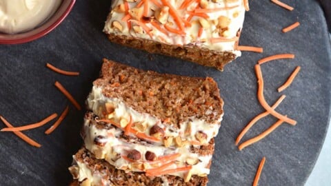 A banana carrot bread with 4 slices laid on the side.