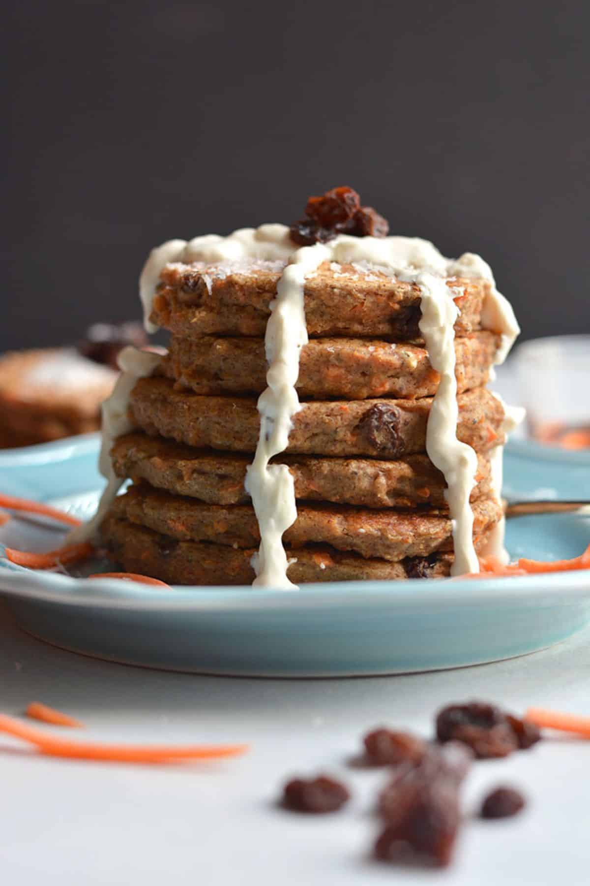 Carrot cake pancakes stacked on a plate.