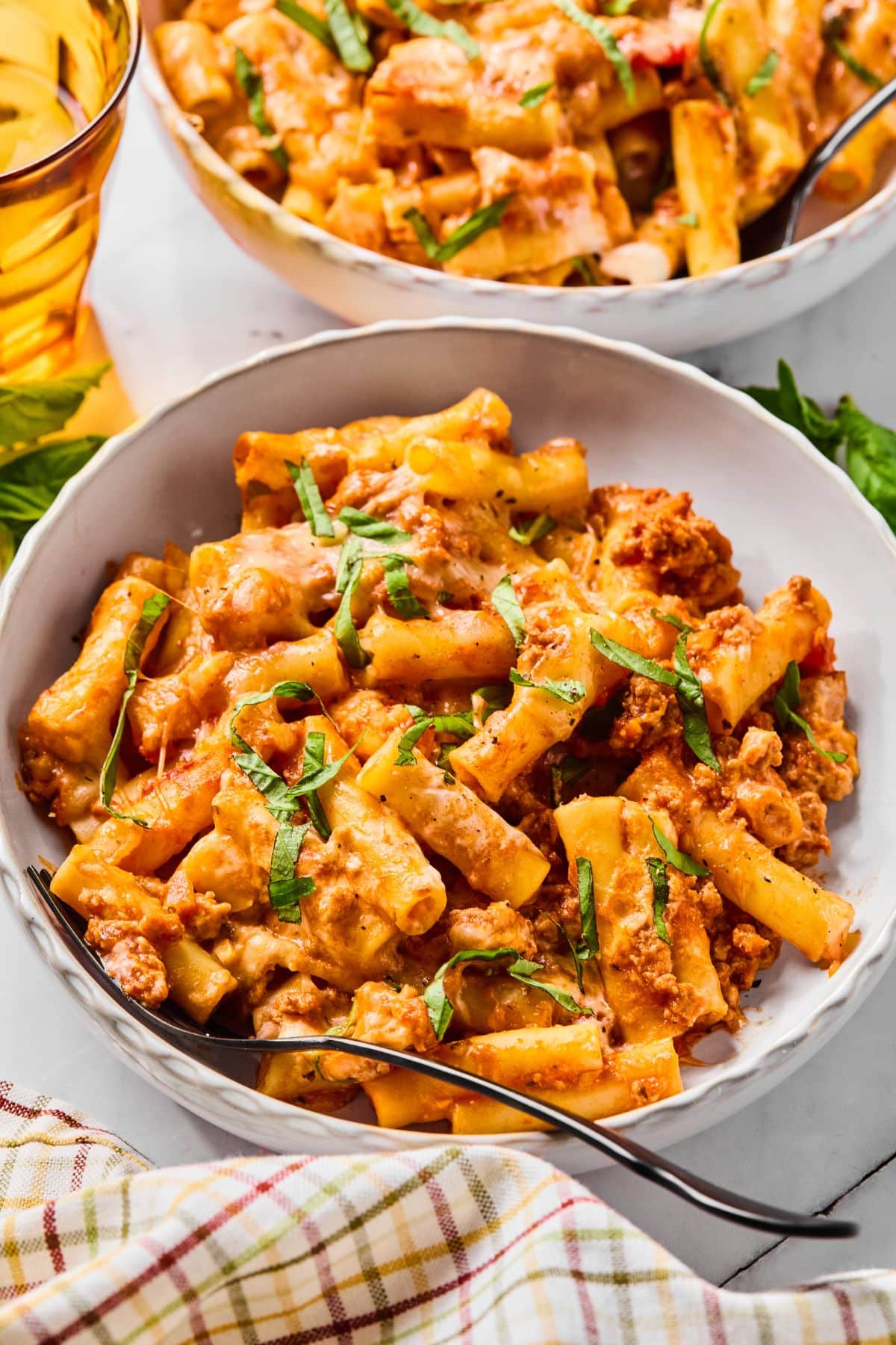 A bowl filled with cottage cheese baked ziti and a fork in the front.