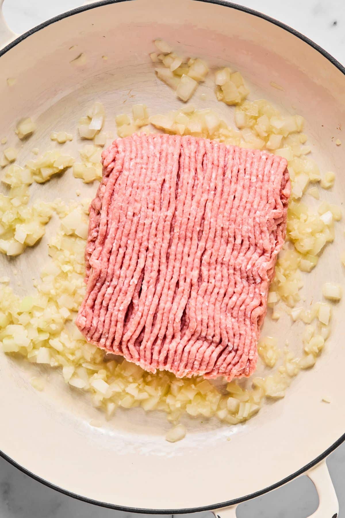 Ground turkey with onions and garlic in a pan.