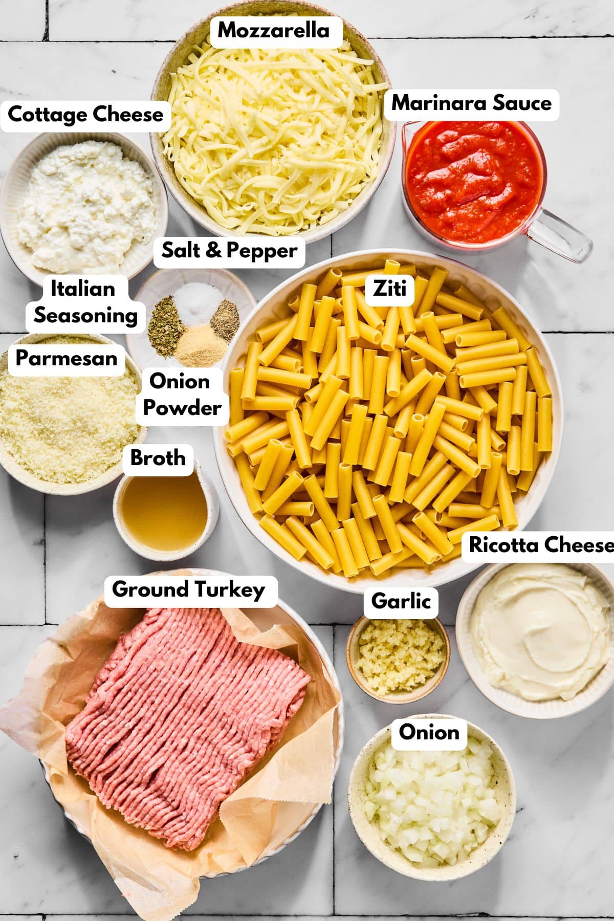 Ingredients to make baked ziti with cottage cheese in bowls on a table.