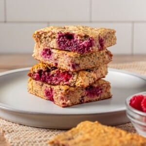 Cottage cheese bars with raspberries and blackberries stacked on a plate.
