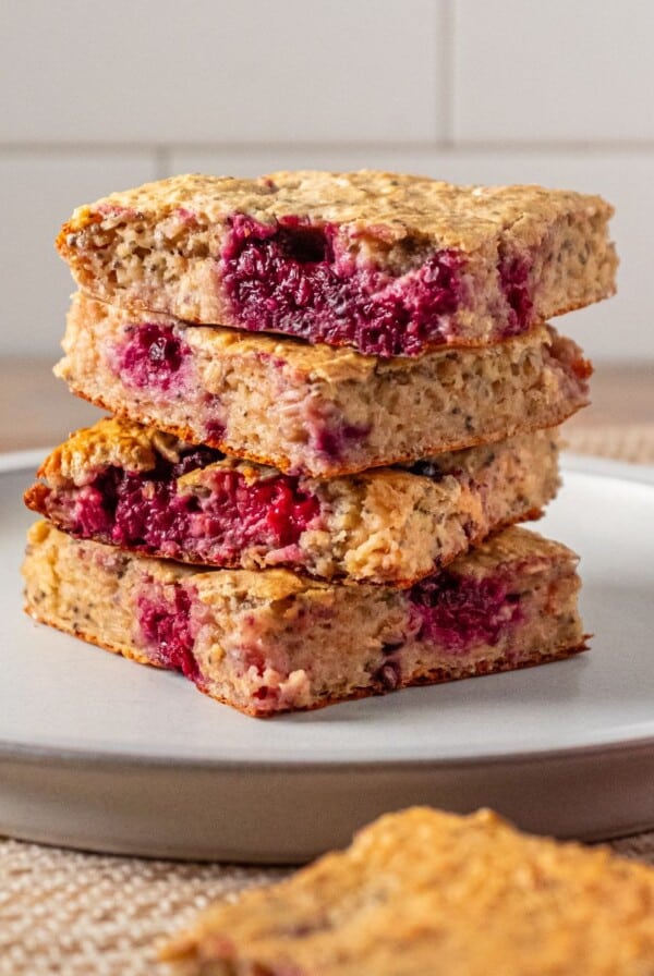 Cottage cheese bars with raspberries and blackberries stacked on a plate.