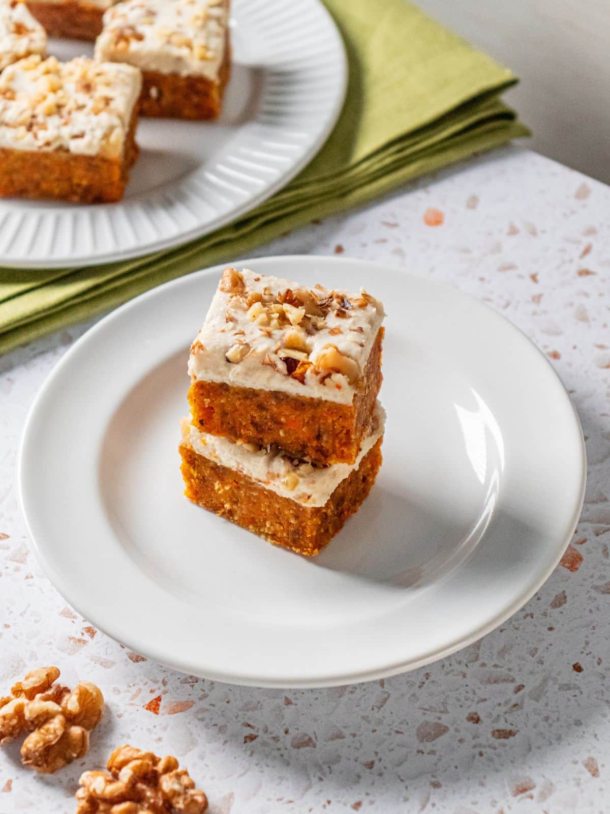 Squares of gluten-free carrot cake stacked on top of one another.