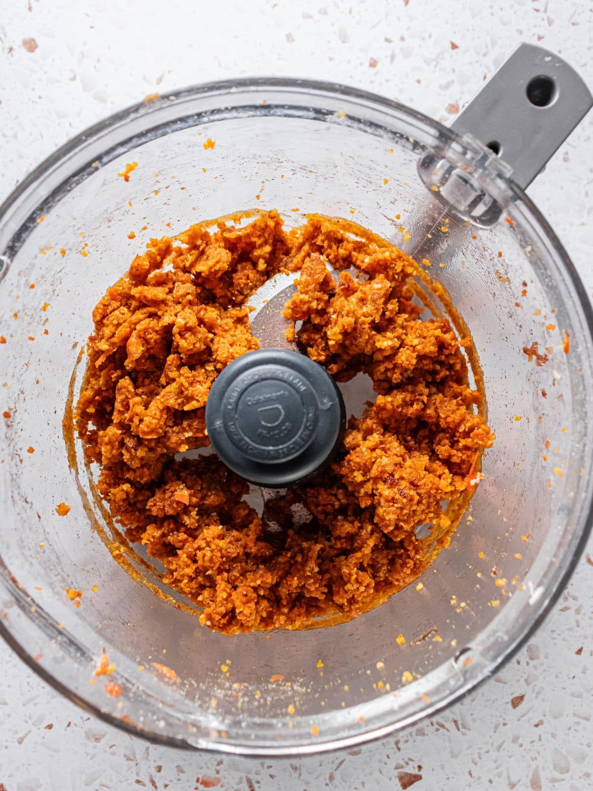 Walnuts, carrots, ginger, nutmeg, cinnamon, coconut flour, coconut oil and coconut flakes added to the food processor.