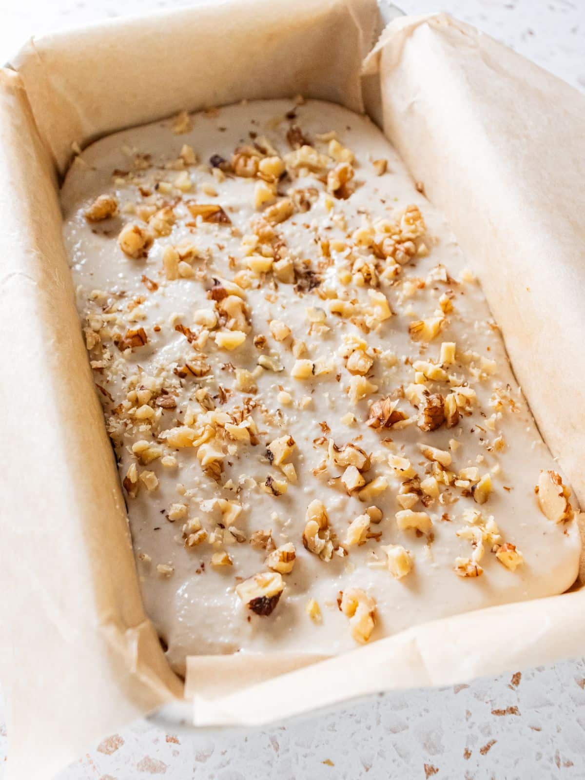 Icing and walnuts sprinkled on top of the cake.