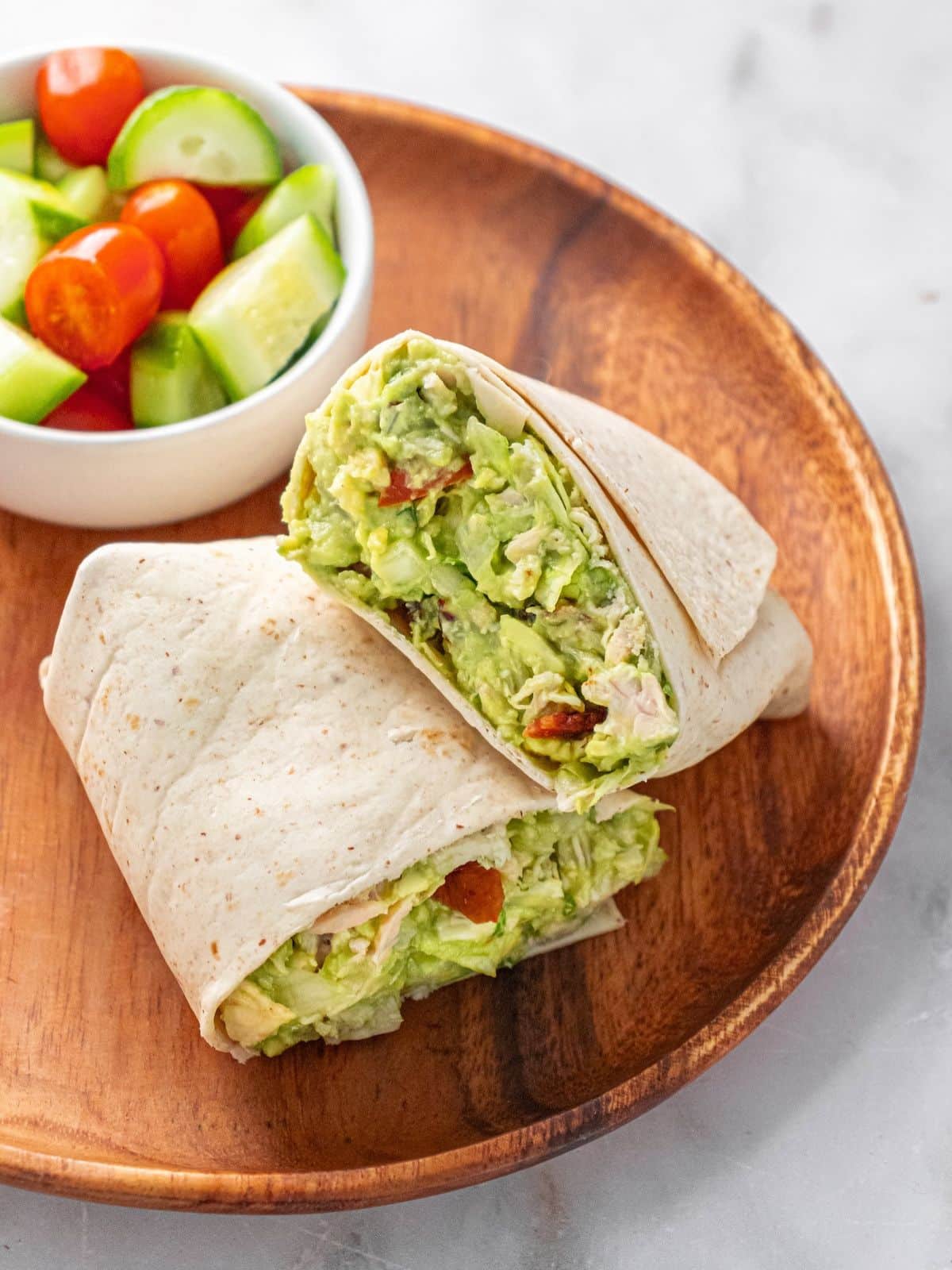Guacamole chicken salad in a wrap with the side of veggies.