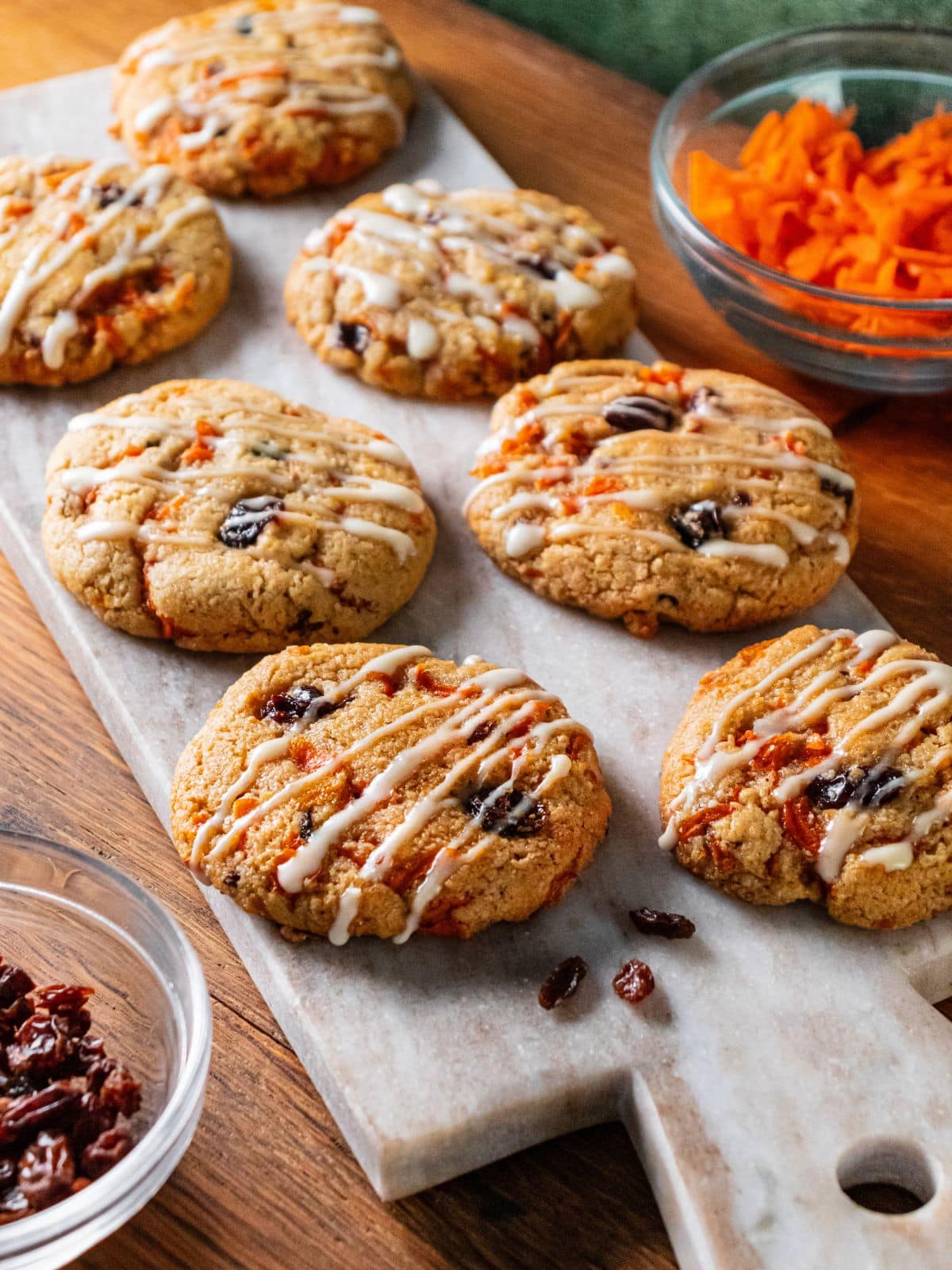 A cutting board with healthy carrot cake cookies on top.