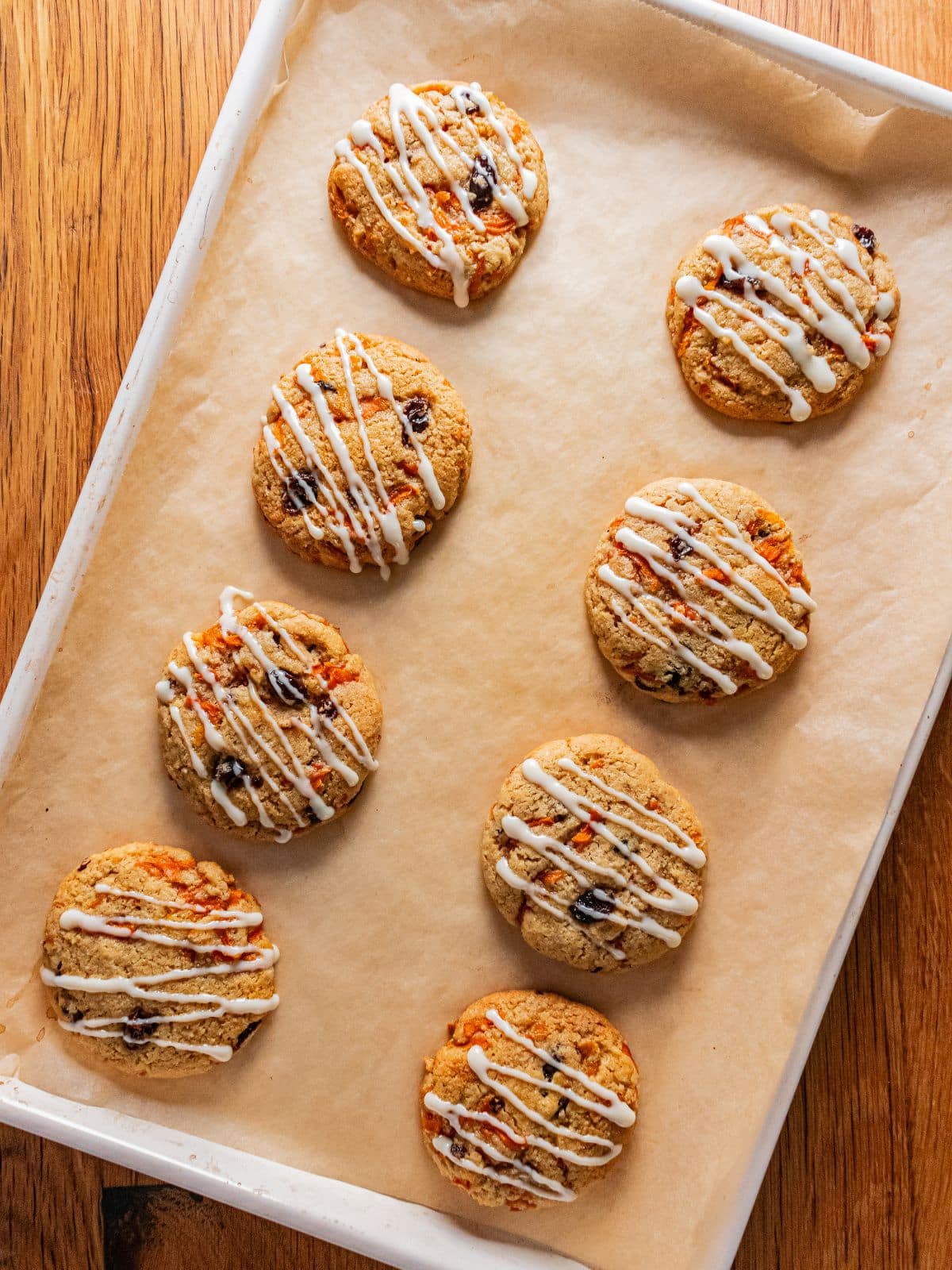 Carrot cake cookies cooling and icing drizzed on top.