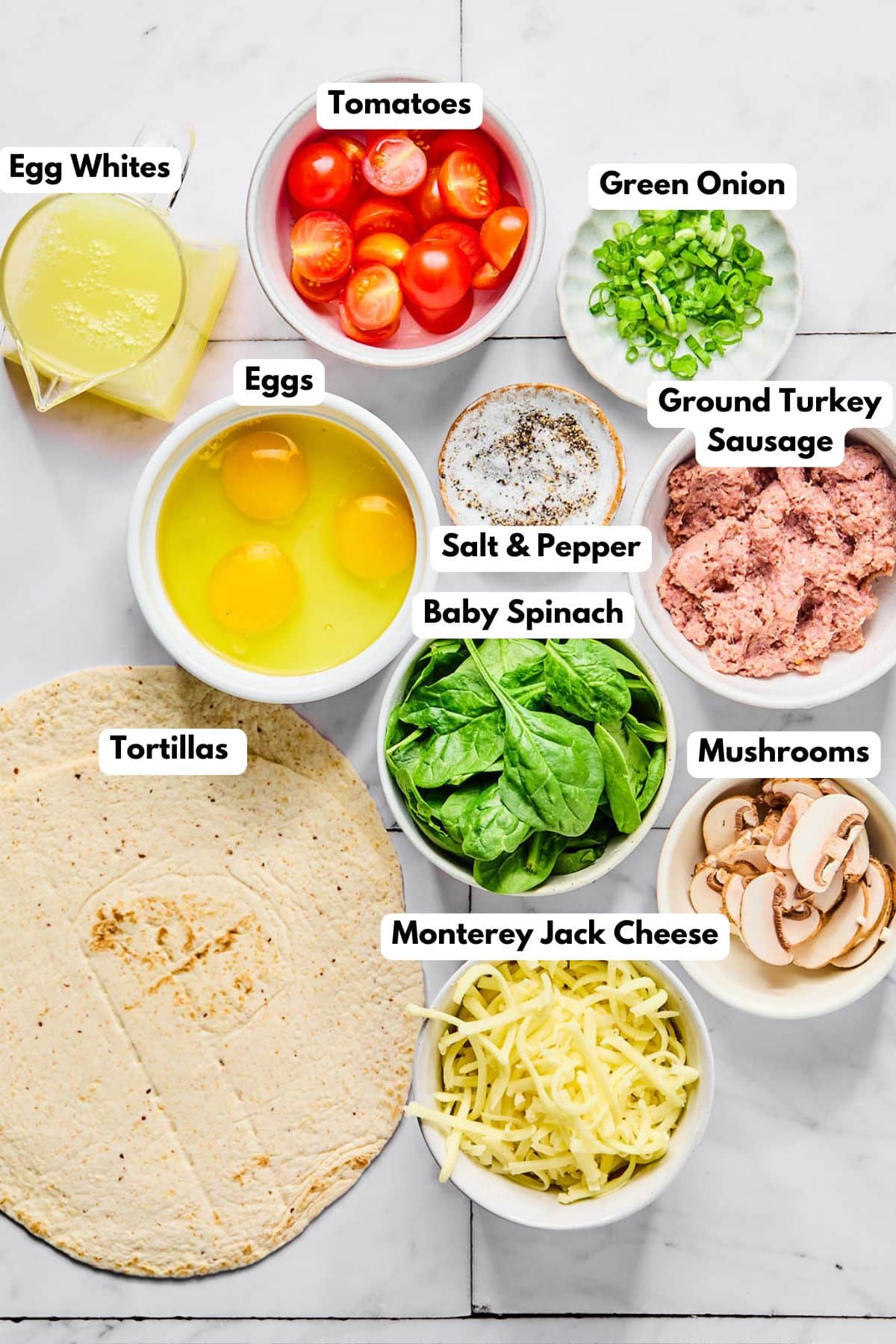 Ingredients to make this breakfast burrito in bowls on a table.
