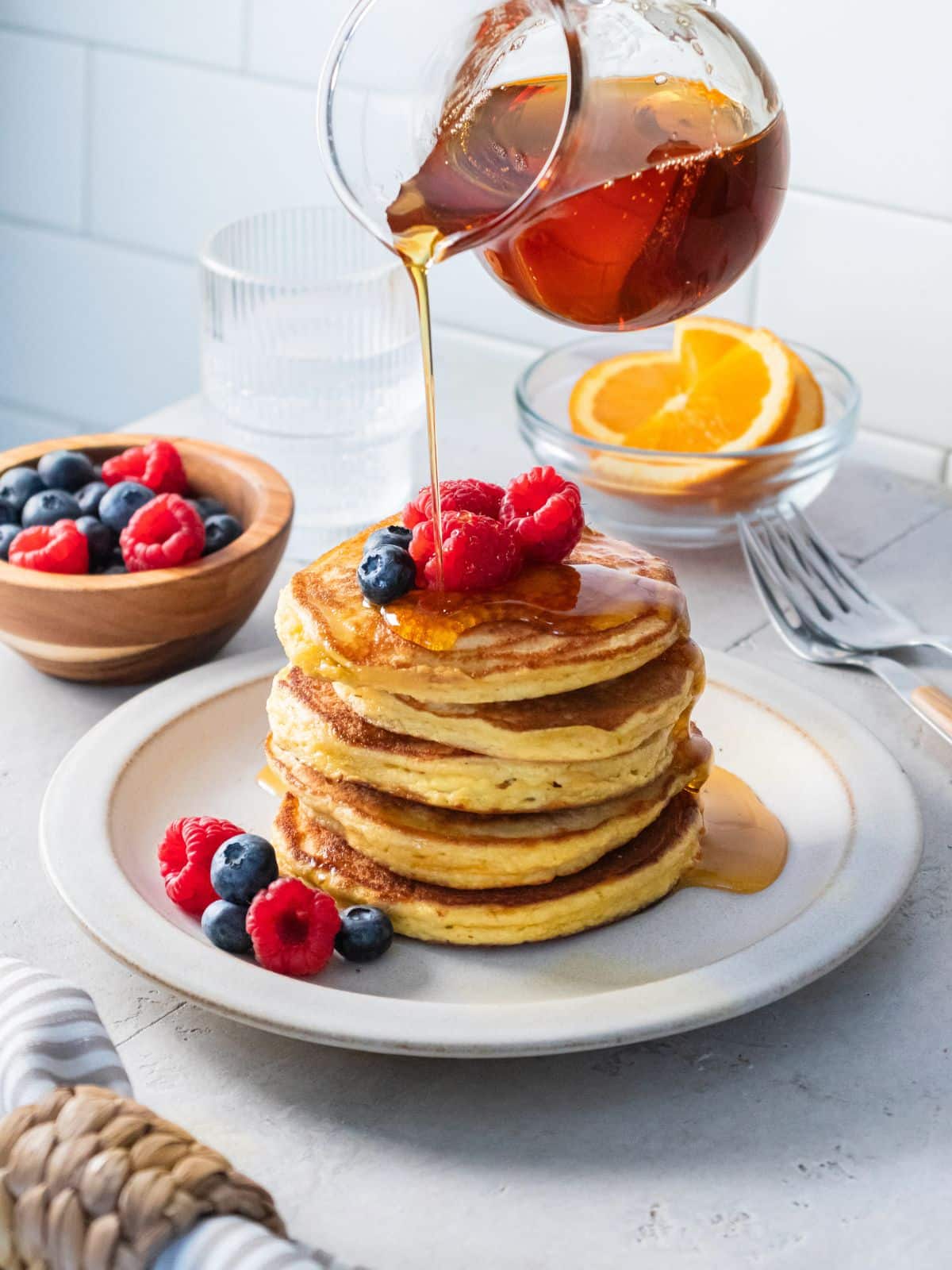 Syrup being poured over a stack of almond flour pancakes.