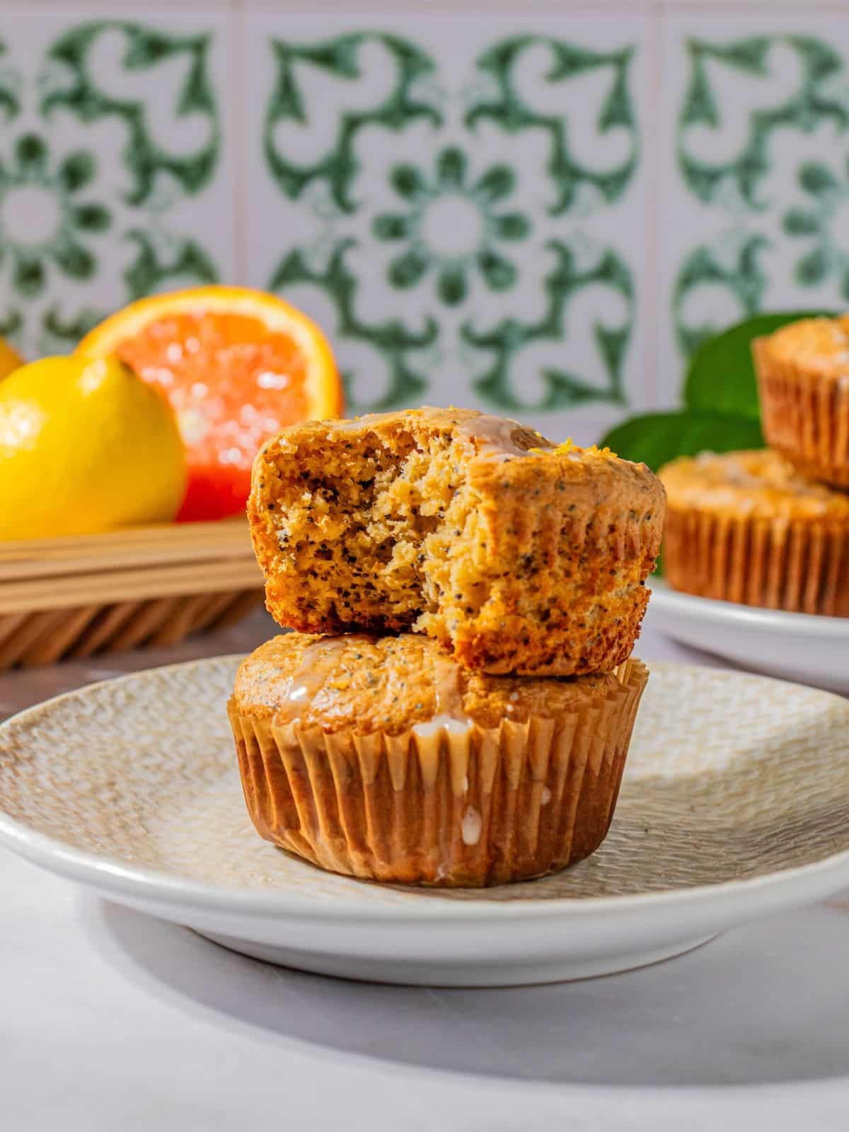 Gluten-free poppy seed muffin stacked on top of another muffin with a bite missing from the one on top.
