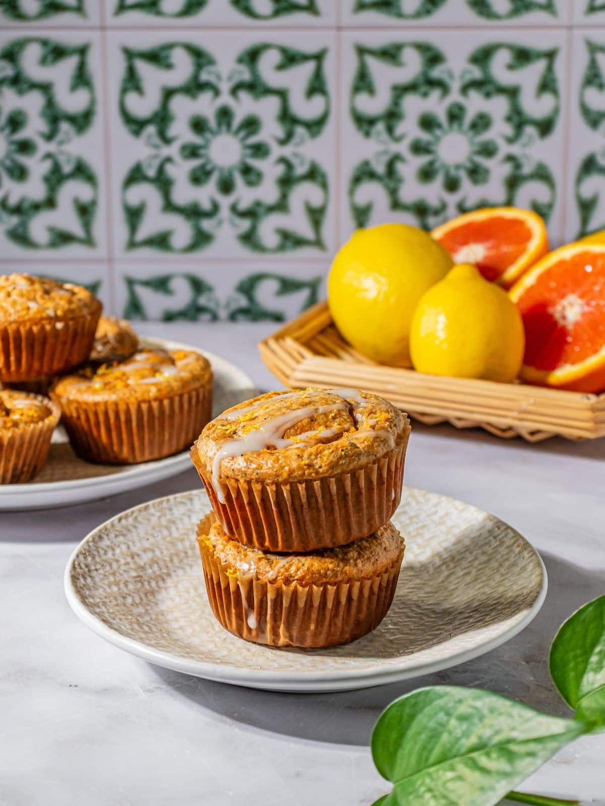 A gluten-free muffin with poppy seeds stacked on another muffin.