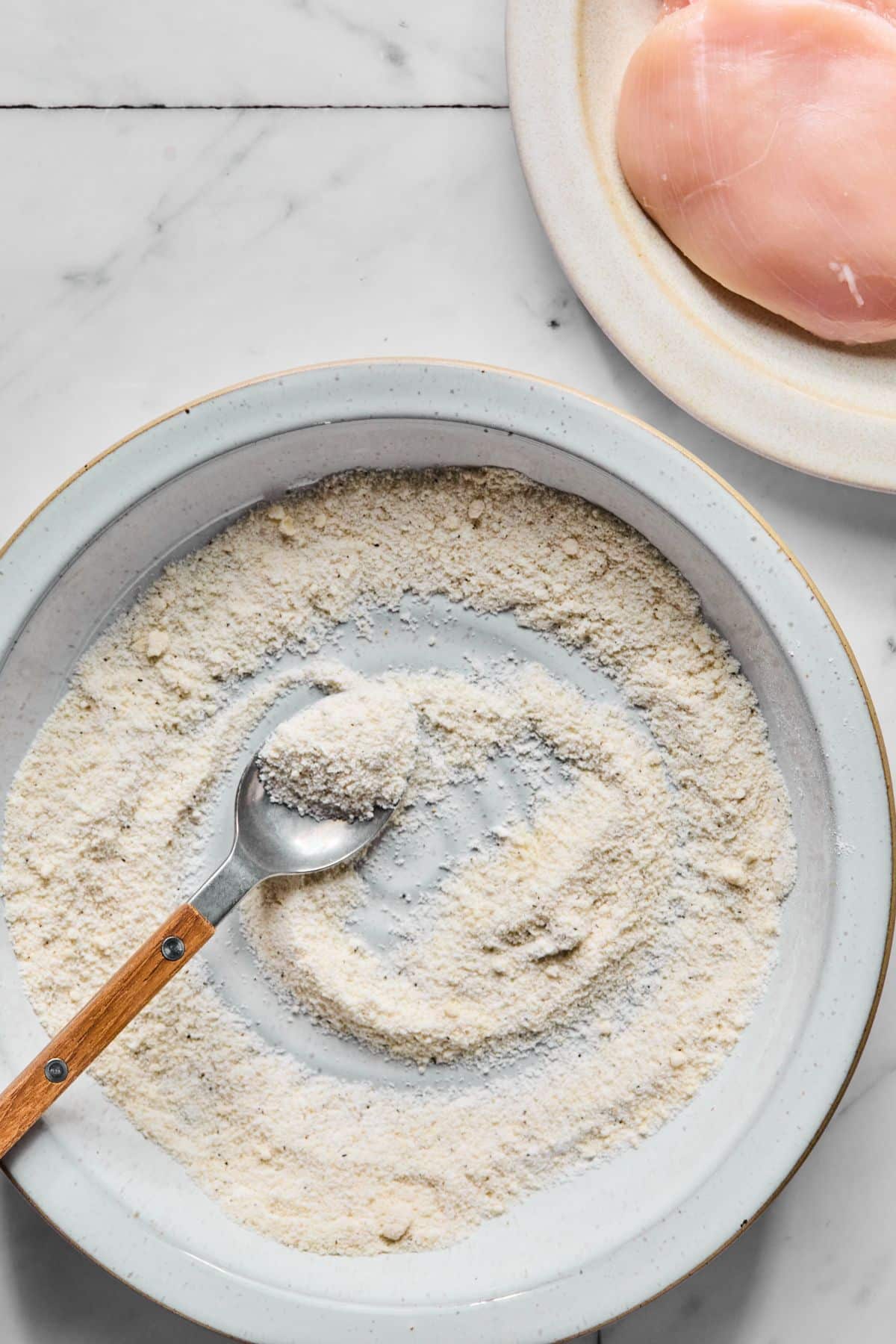Almond and tapioca flours with salt and pepper in a shallow dish.