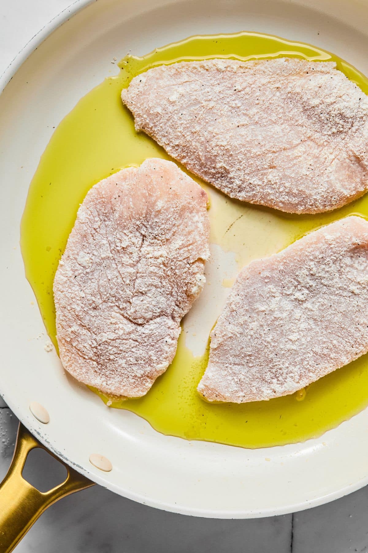 The dipped chicken in a skillet to sear.