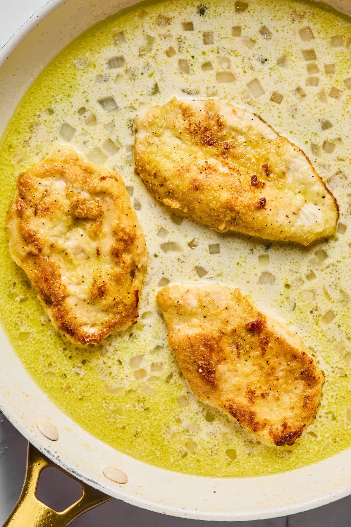 The chicken added back into the pan to finish cooking.
