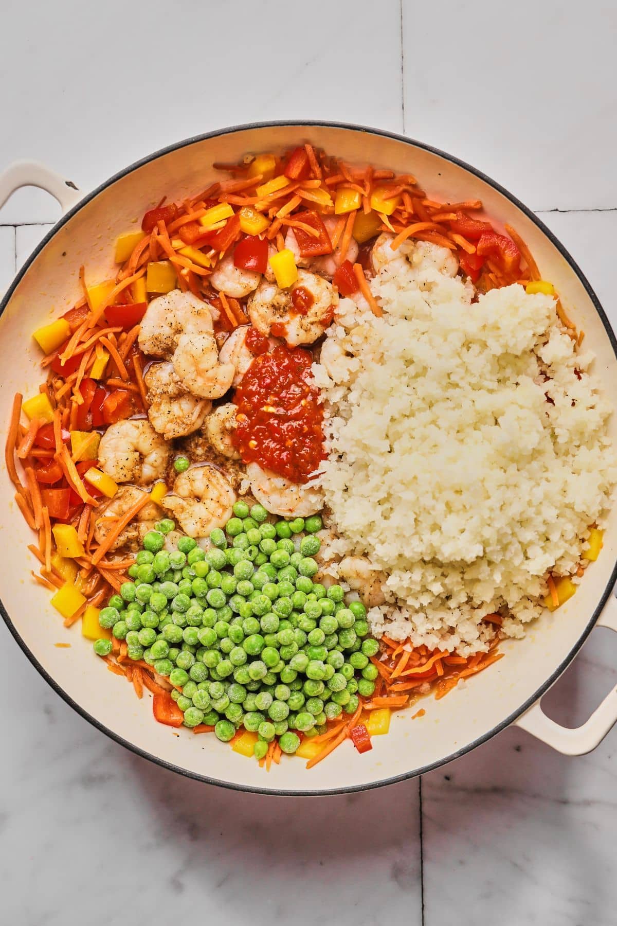 Cauliflower, peas and chili paste added to the pan.