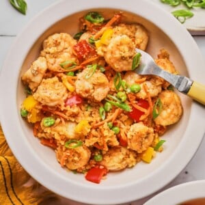 A fork picking up some shrimp fried rice.