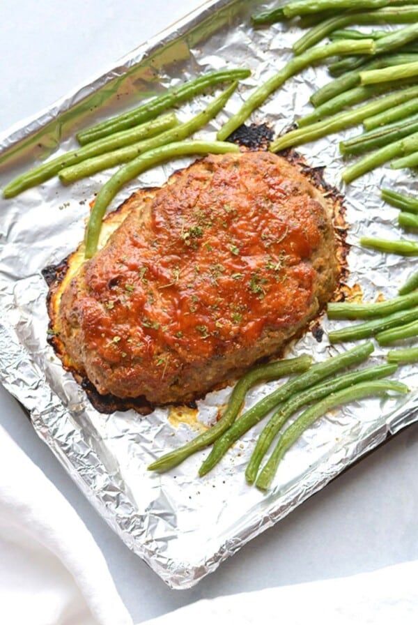 A healthy turkey meatloaf on a sheetpan with green beans.