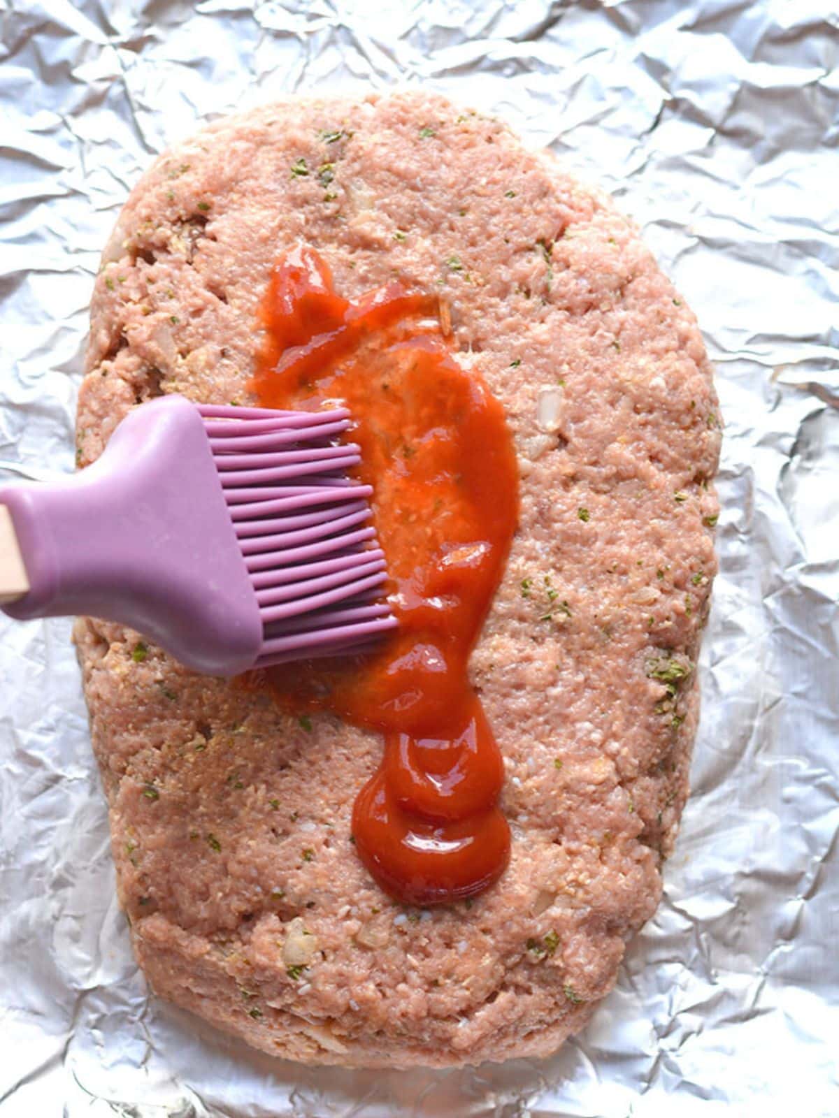 The mixture formed into a loaf and ketchup brushed on top.