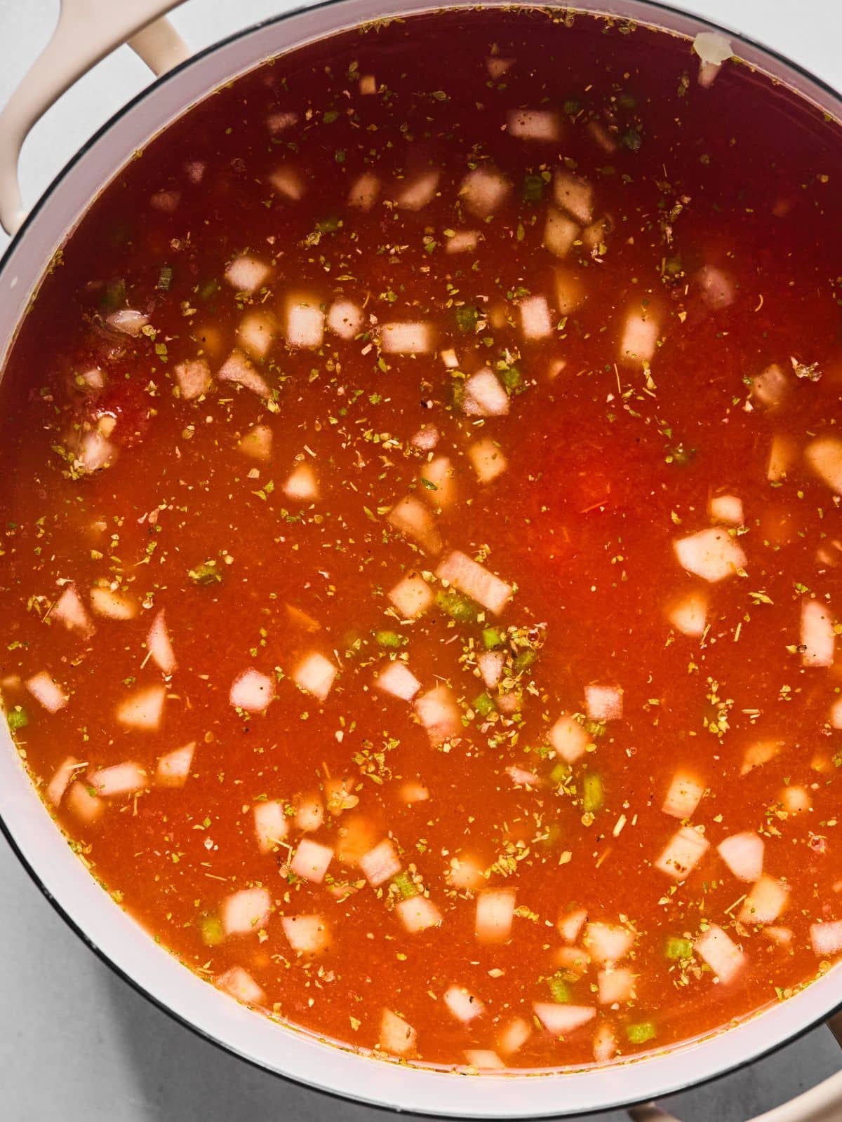 Broth and crushed tomatoes added to the pan.