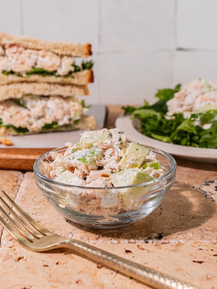 Apple chicken salad in a bowl with a fork in front of it.