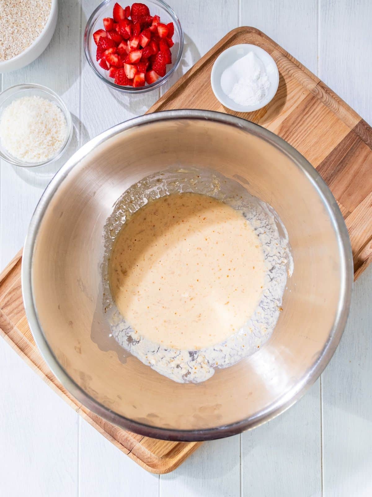 Egg, Greek yogurt, coconut sugar, banana, milk and vanilla extract mixed in a bowl.