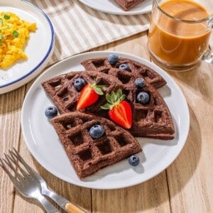 Chocolate waffles with blueberries and strawberries on top.