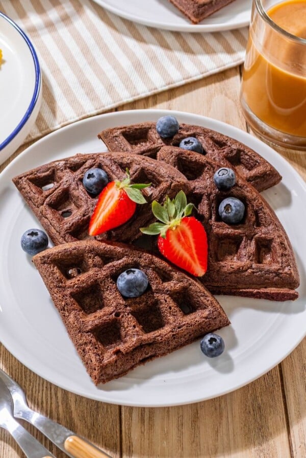 Chocolate waffles with blueberries and strawberries on top.