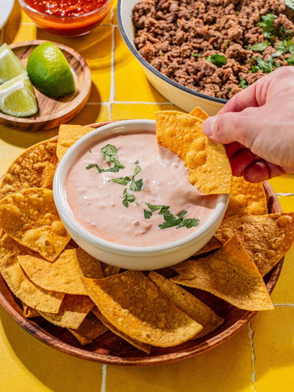 A chip dipping into salsa dressing.