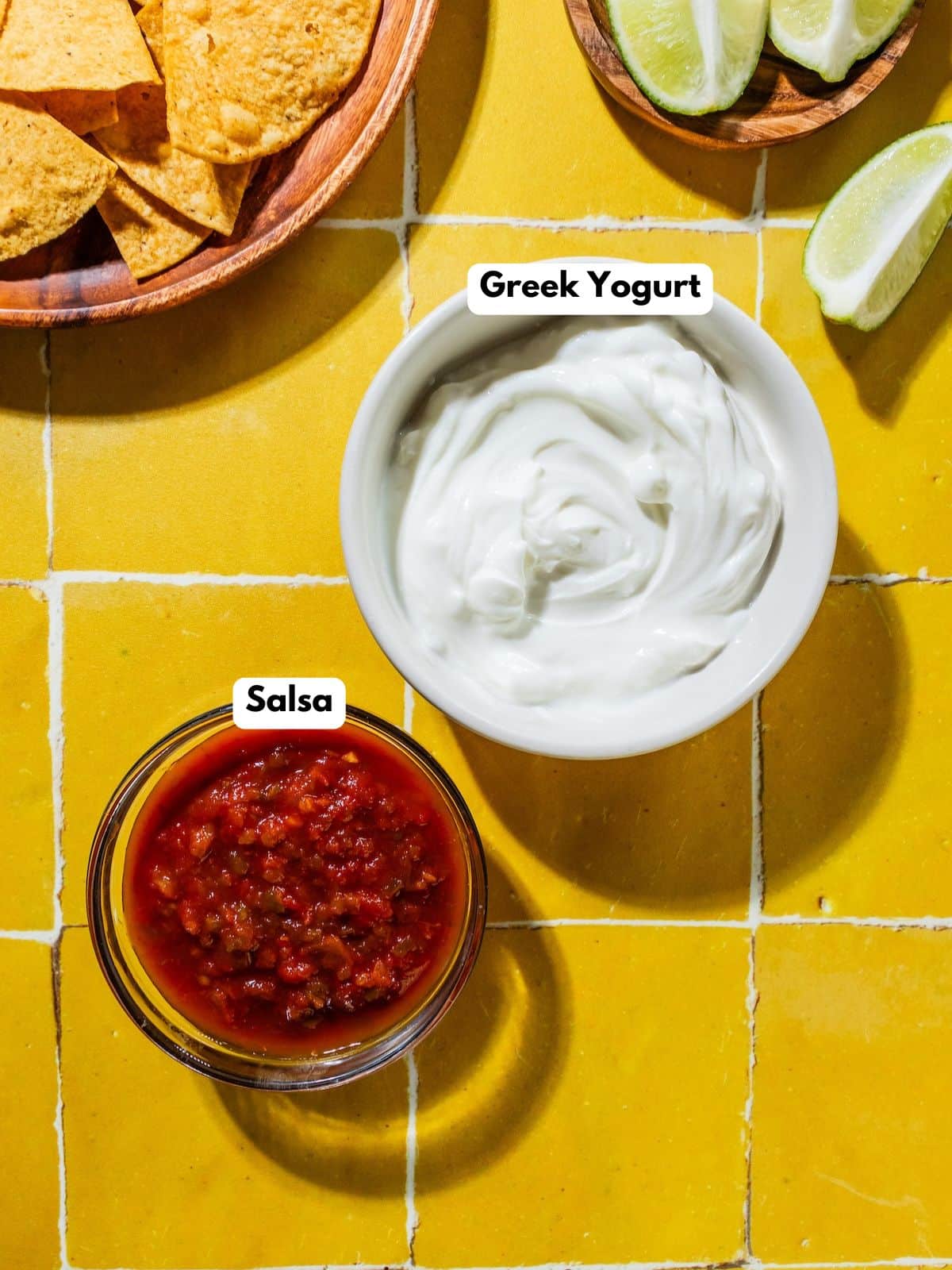 Ingredients to make this salsa dressing in bowls on a table.