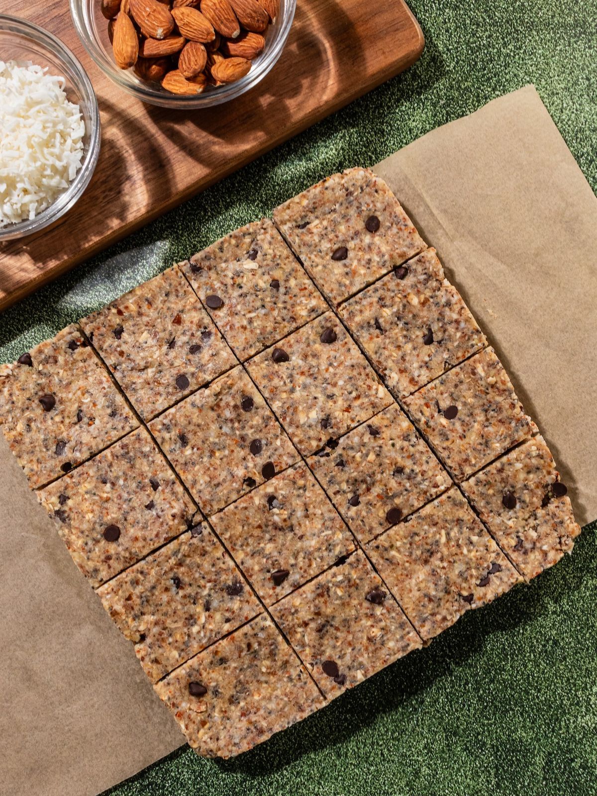 The granola bars cut into squares on a parchment paper.