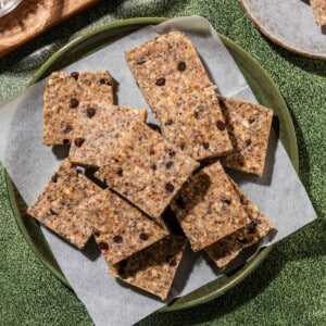 Gluten free granola bars in a green plate over parchment paper.