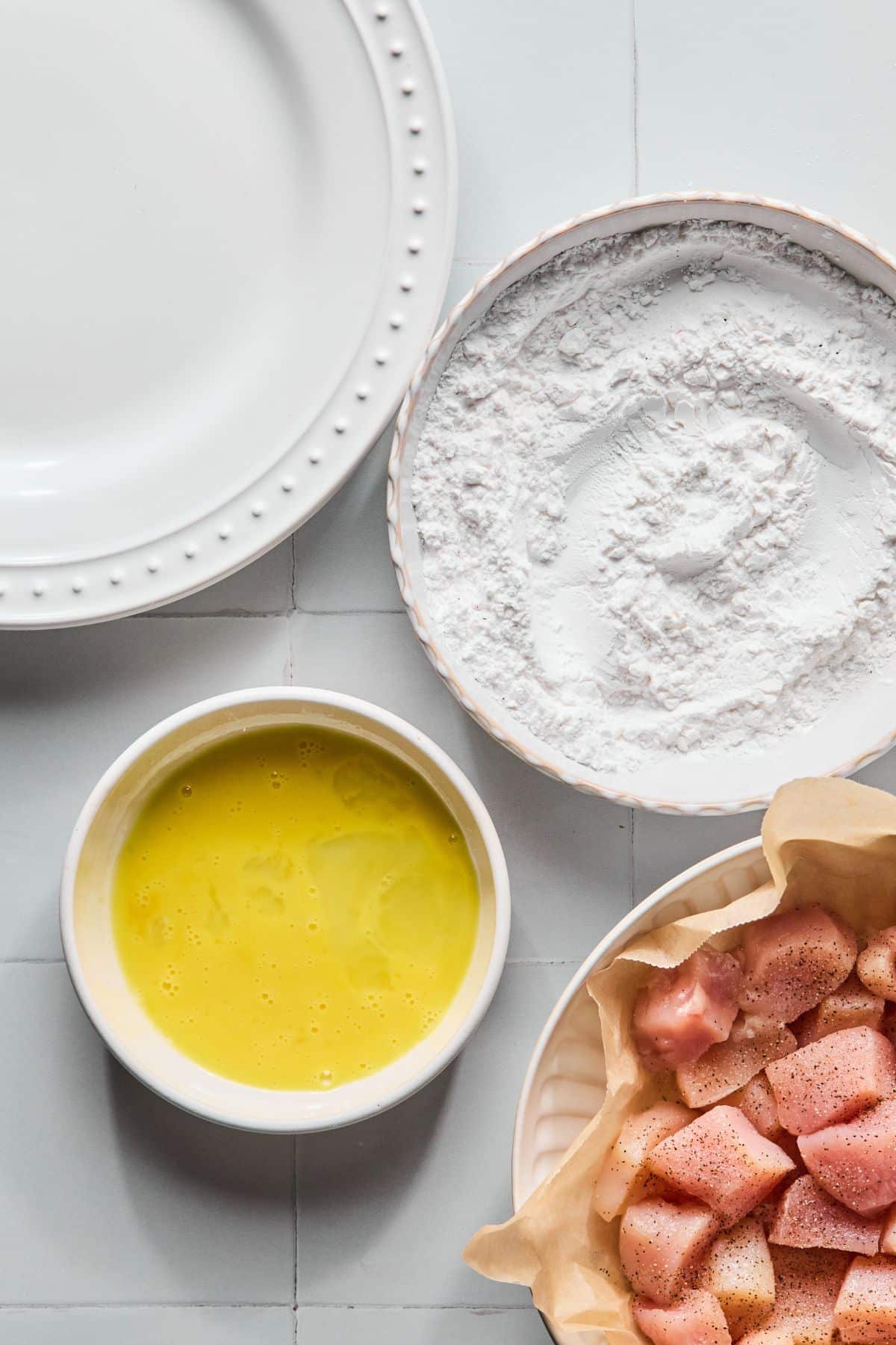 Arrowroot powder in a plate and eggs in a bowl.