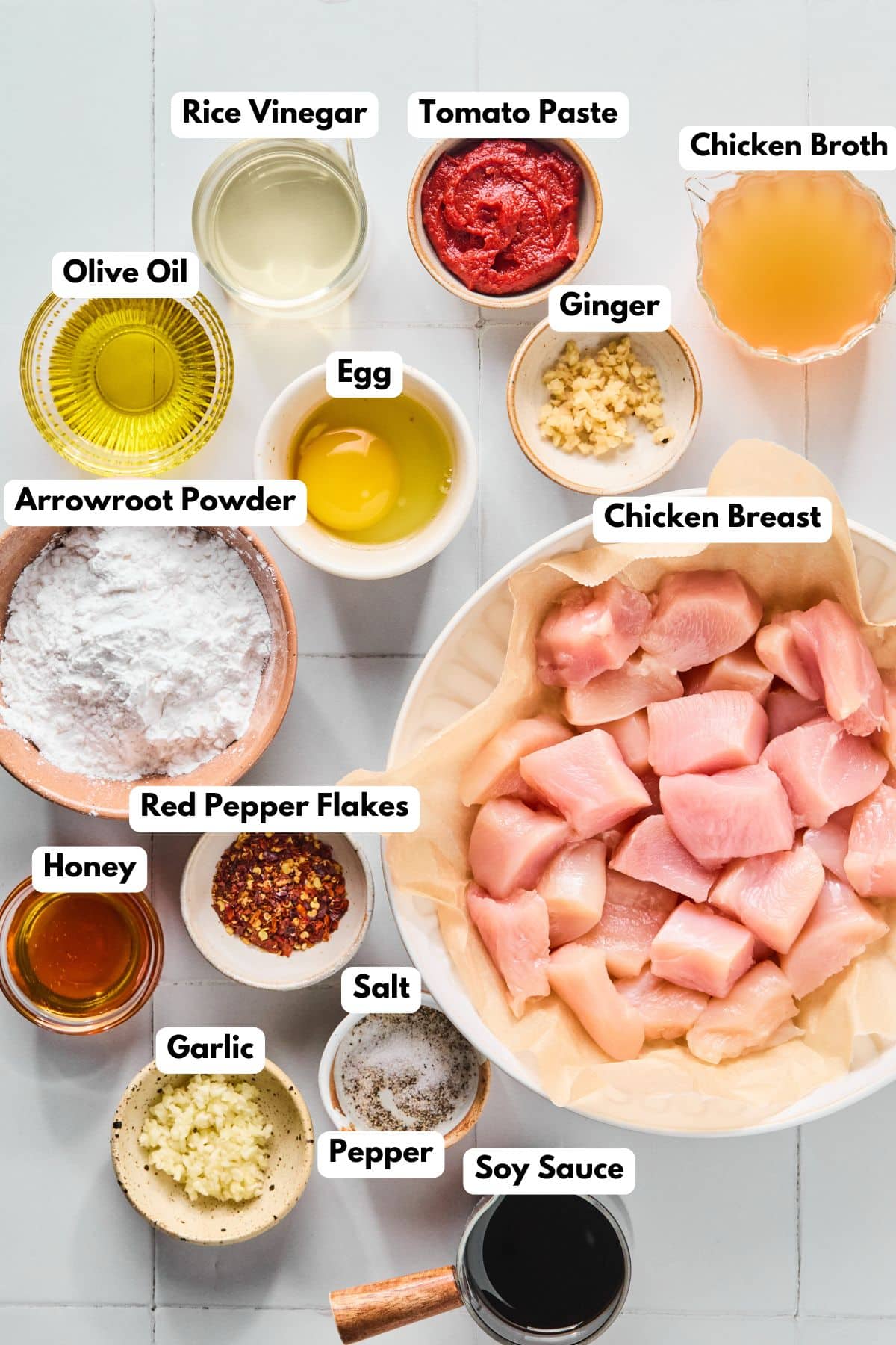 Ingredients to make this healthy General Tso's chicken in bowls on a table.