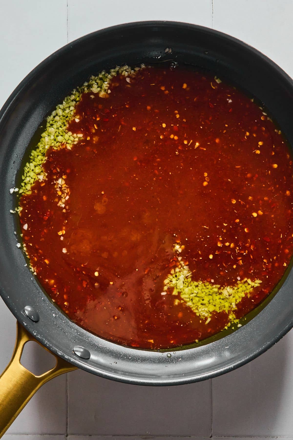 The sauce added to the garlic and ginger in a pan.