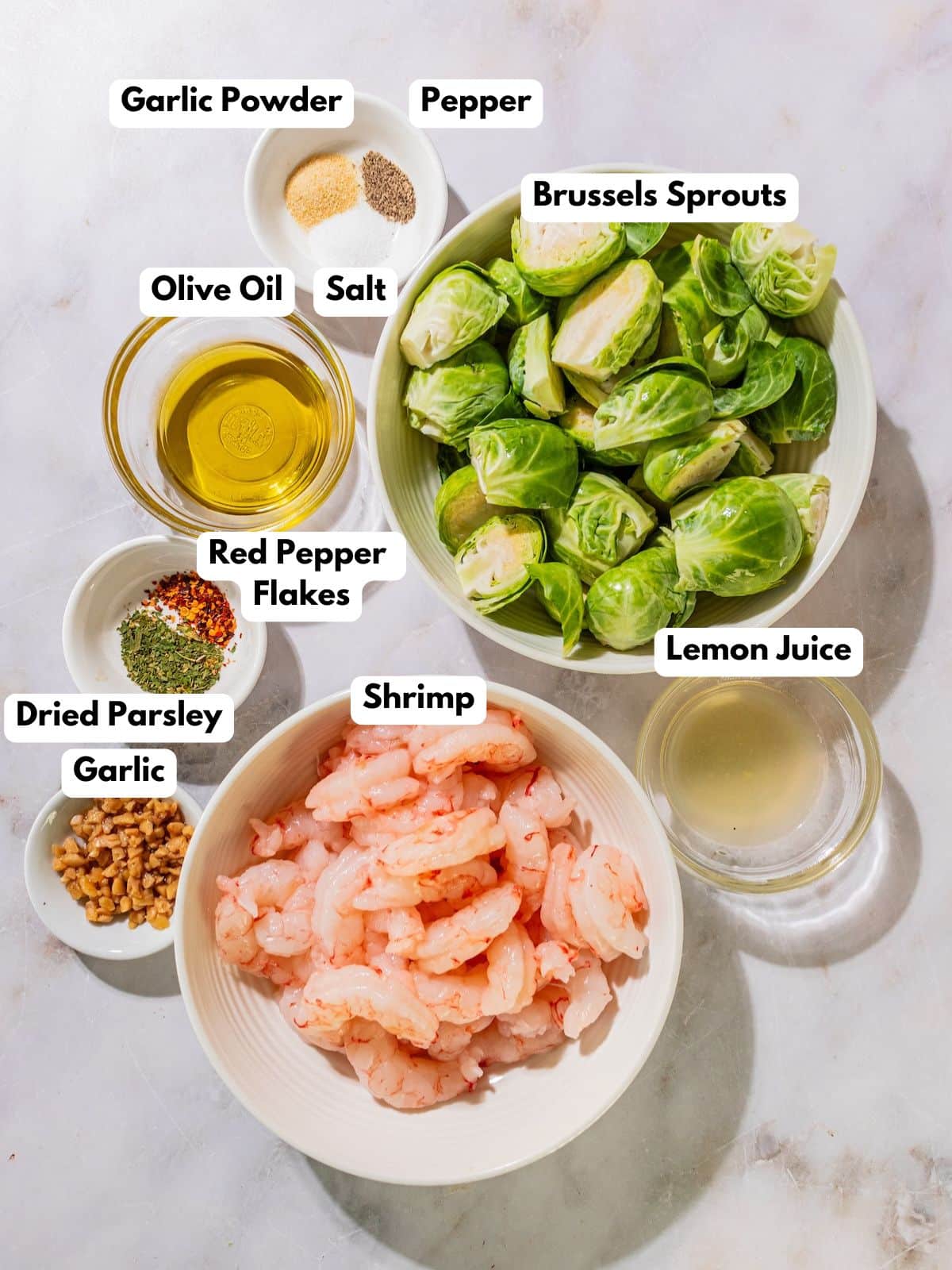 Ingredients to make oven baked shrimp in bowls on a table.