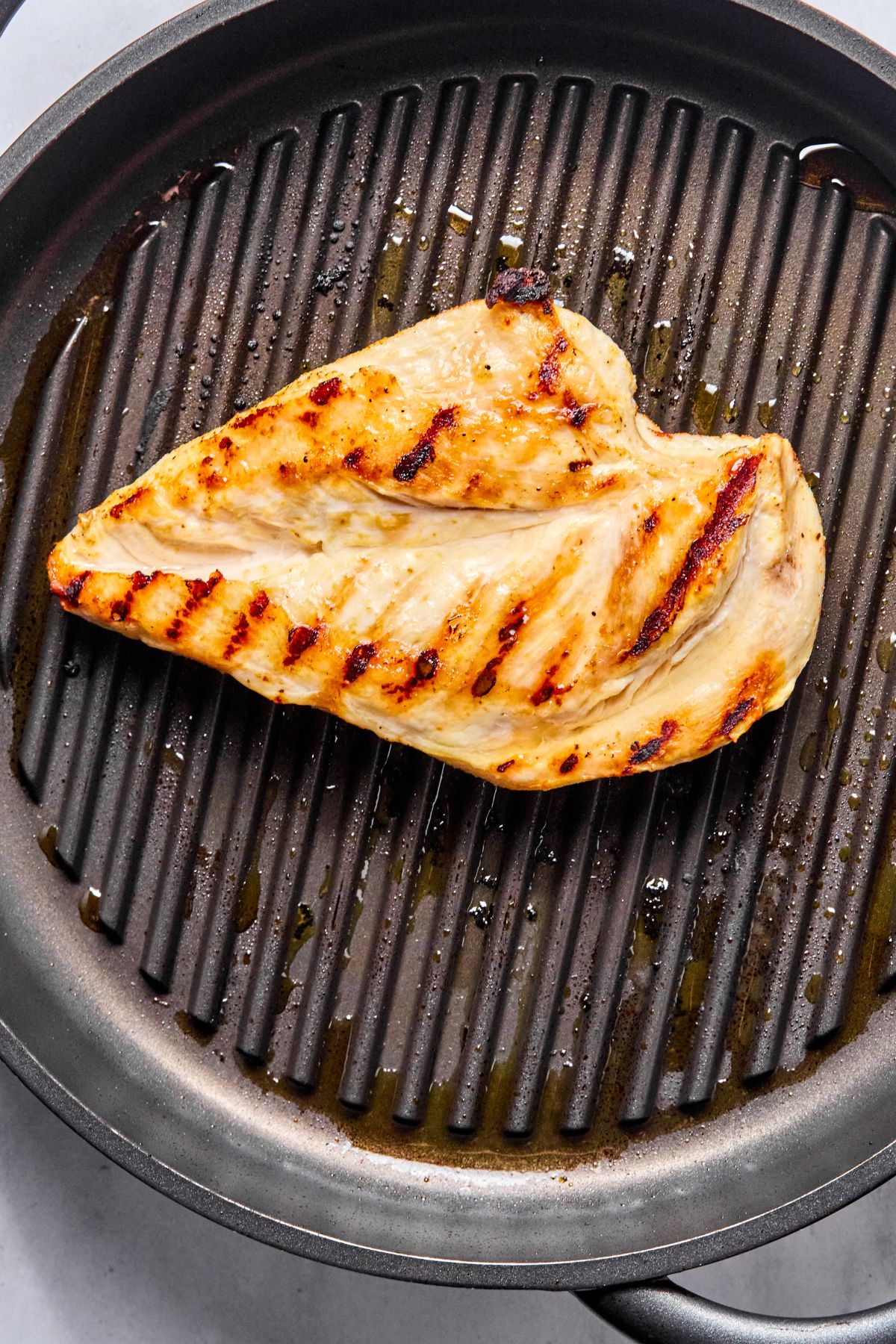 The chicken flipped on the skillet to cook on the other side.