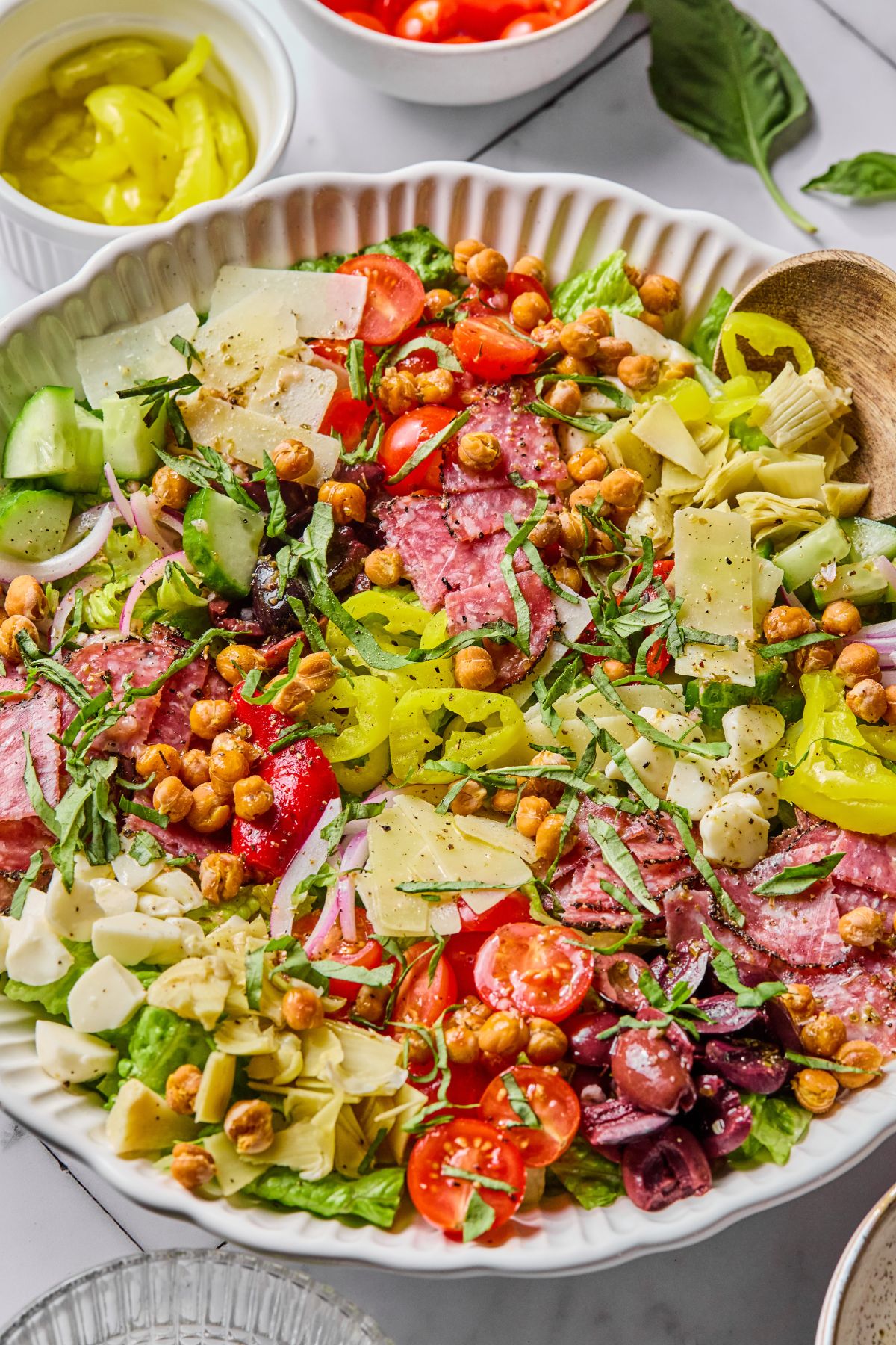 A wooden spoon scooping up some antipasto salad.