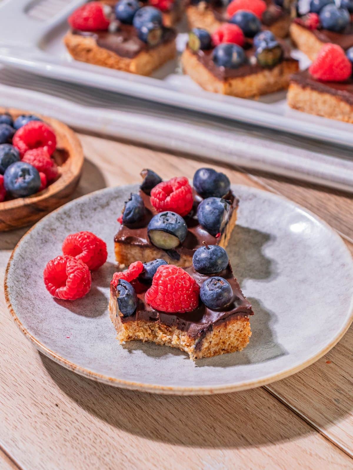 Two slices of berry bars with raspberries on the side.