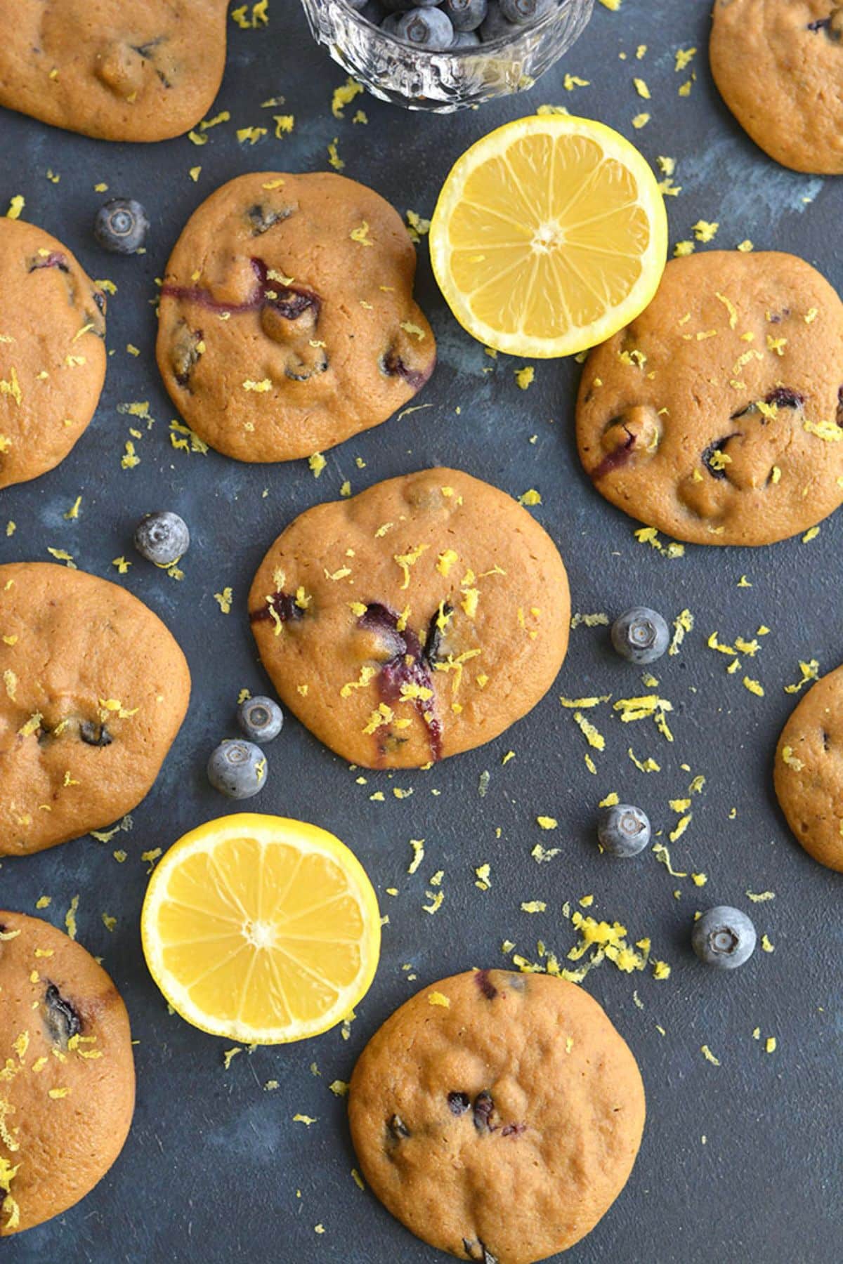 Cookies with blueberries on a table with lemons around.