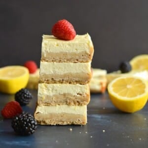 Healthy lemon bars stacked with a raspberry on top.