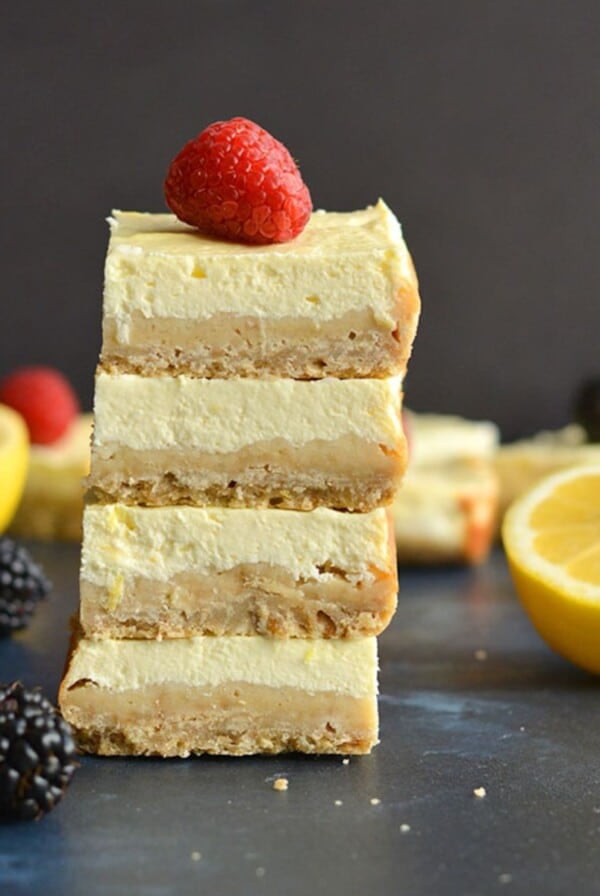 Healthy lemon bars stacked with a raspberry on top.