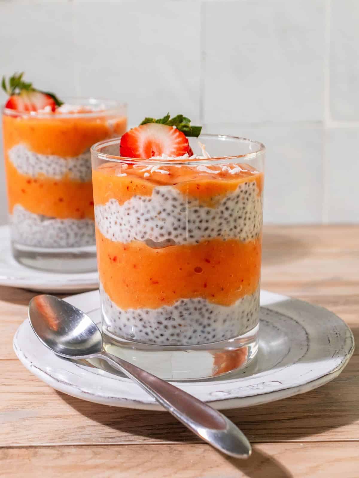 Mango chia pudding with a strawberry on top as garnish.