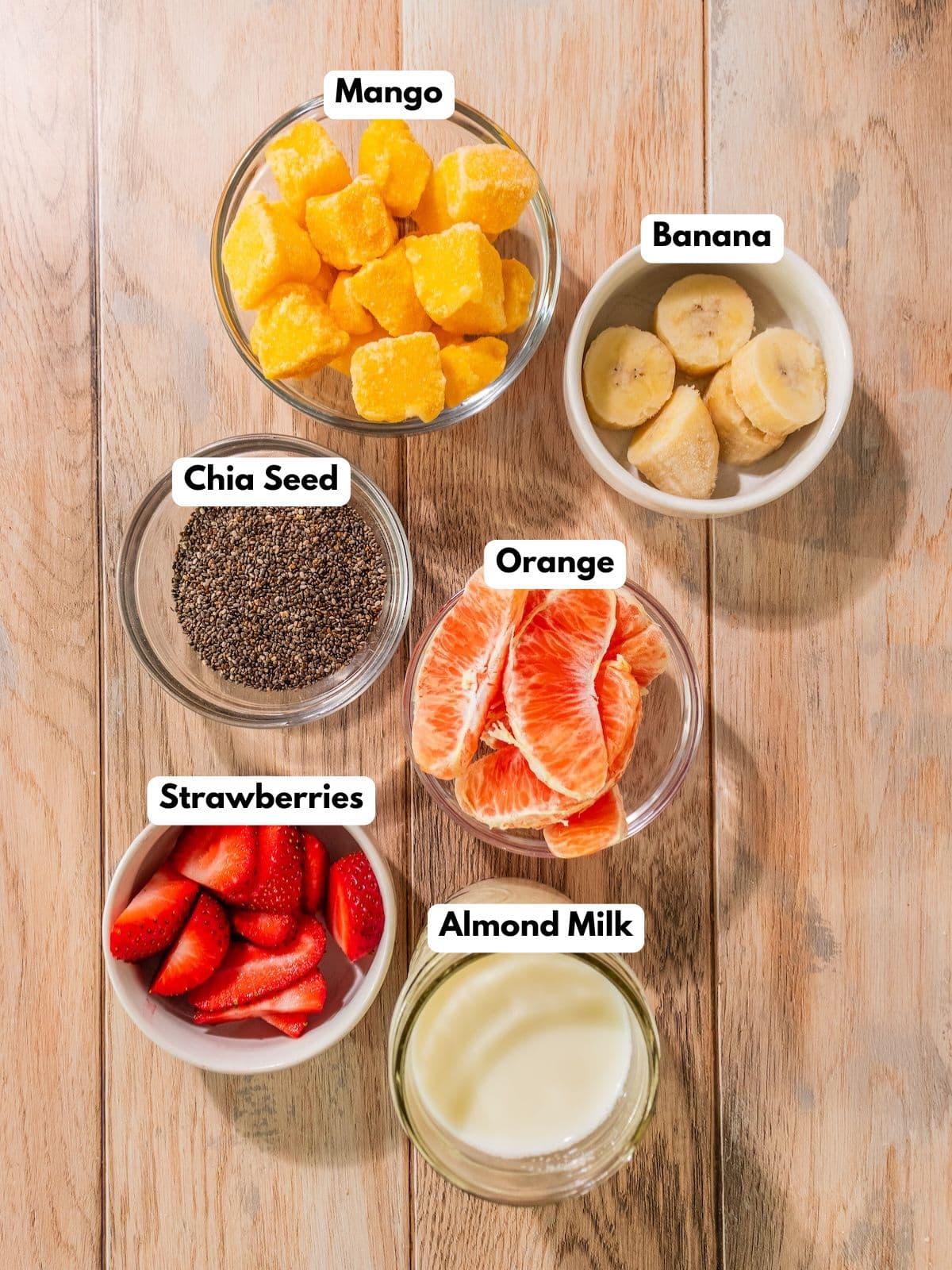 Ingredients to make this mango chia pudding in bowls on a table.