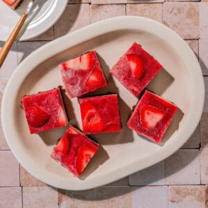 Squares of no bake strawberry cake on a platter.