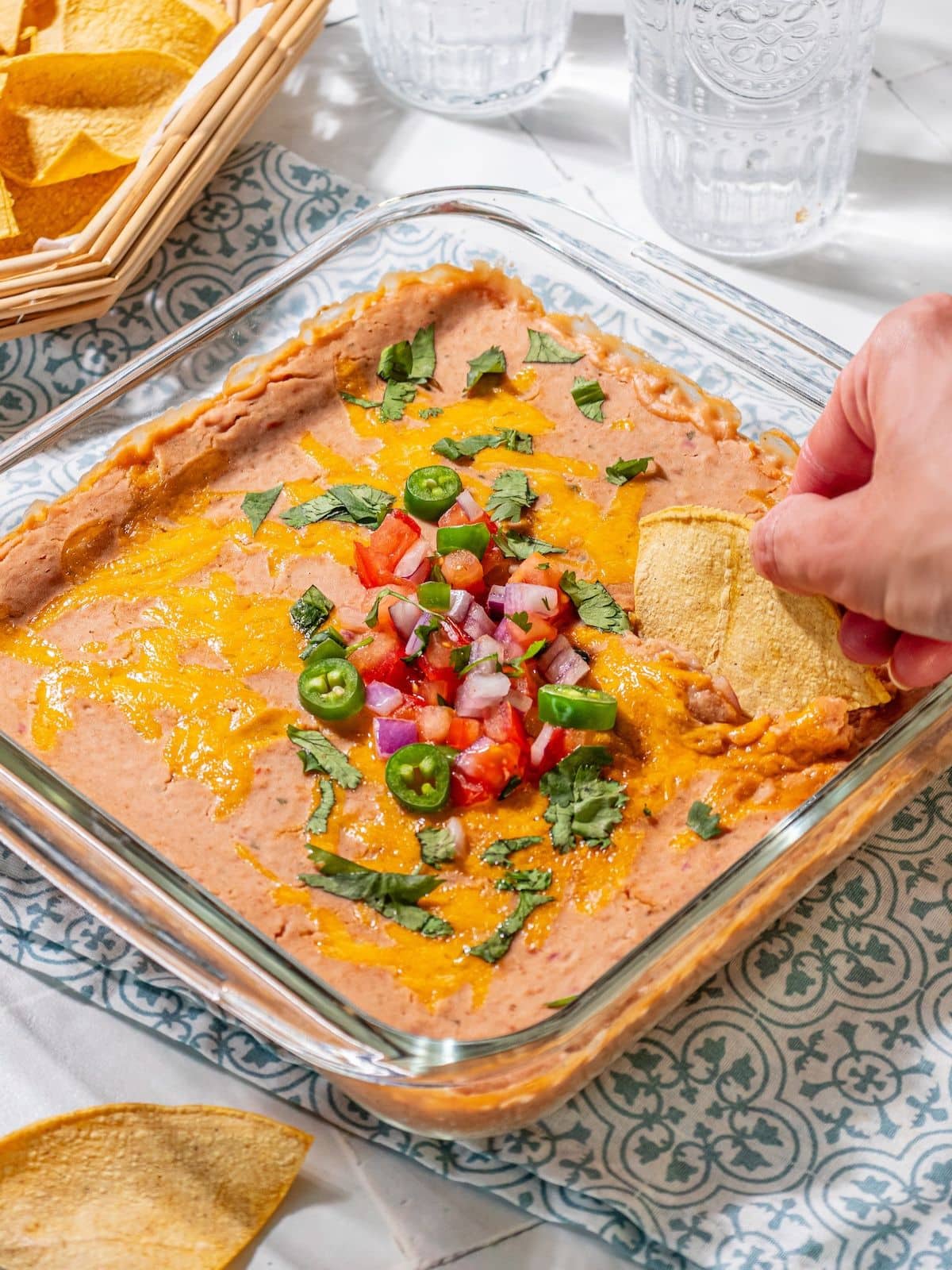 A chip scooping out some bean dip.