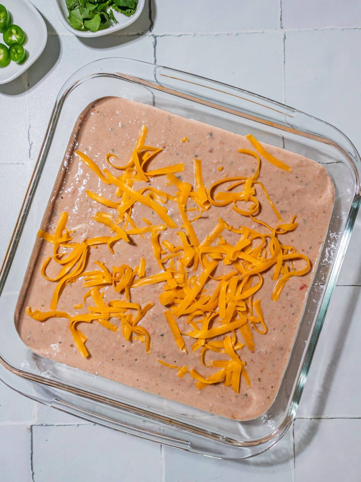 The blended beans poured into a casserole dish and cheese on top.