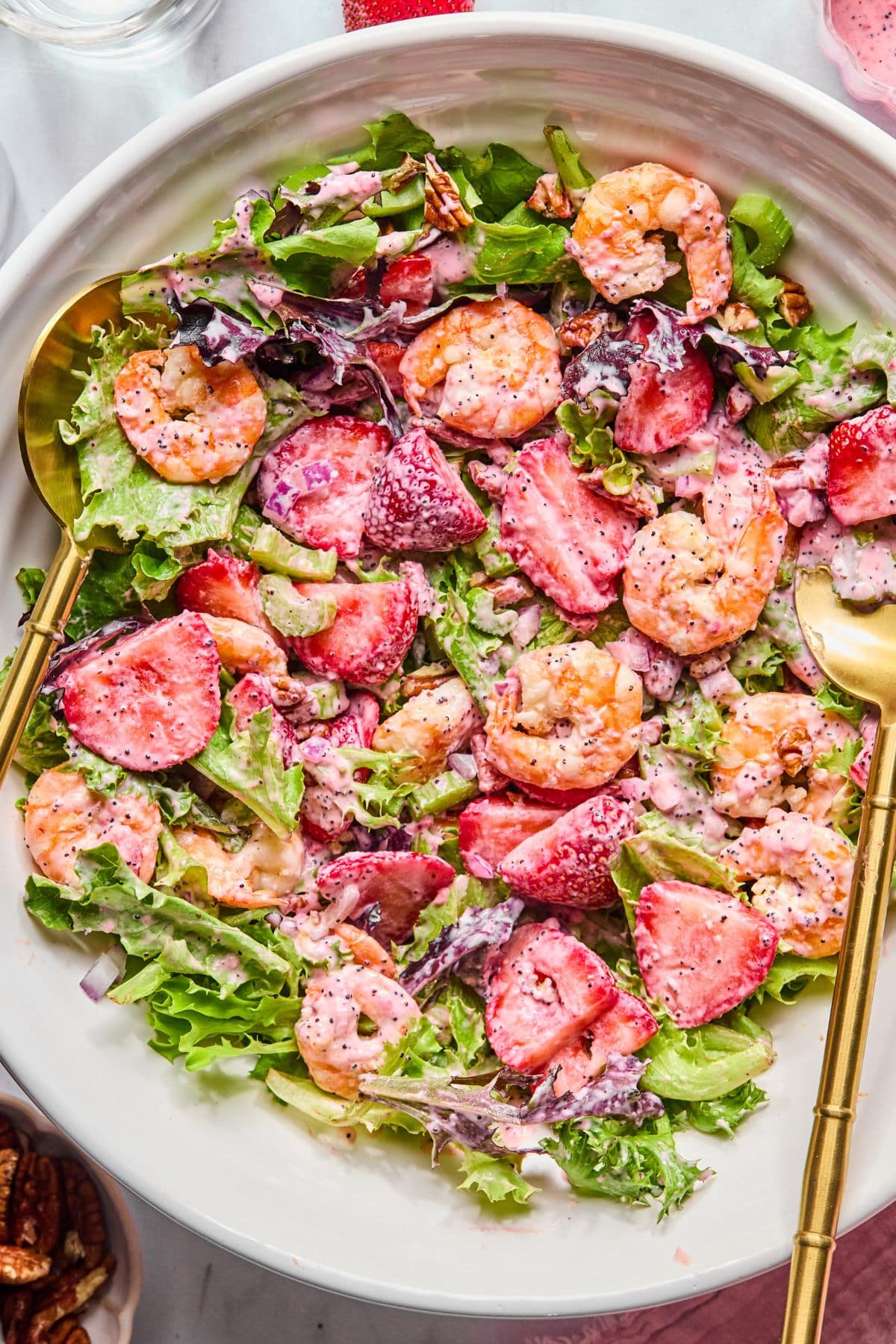A salad with shrimp and strawberries in a bowl.