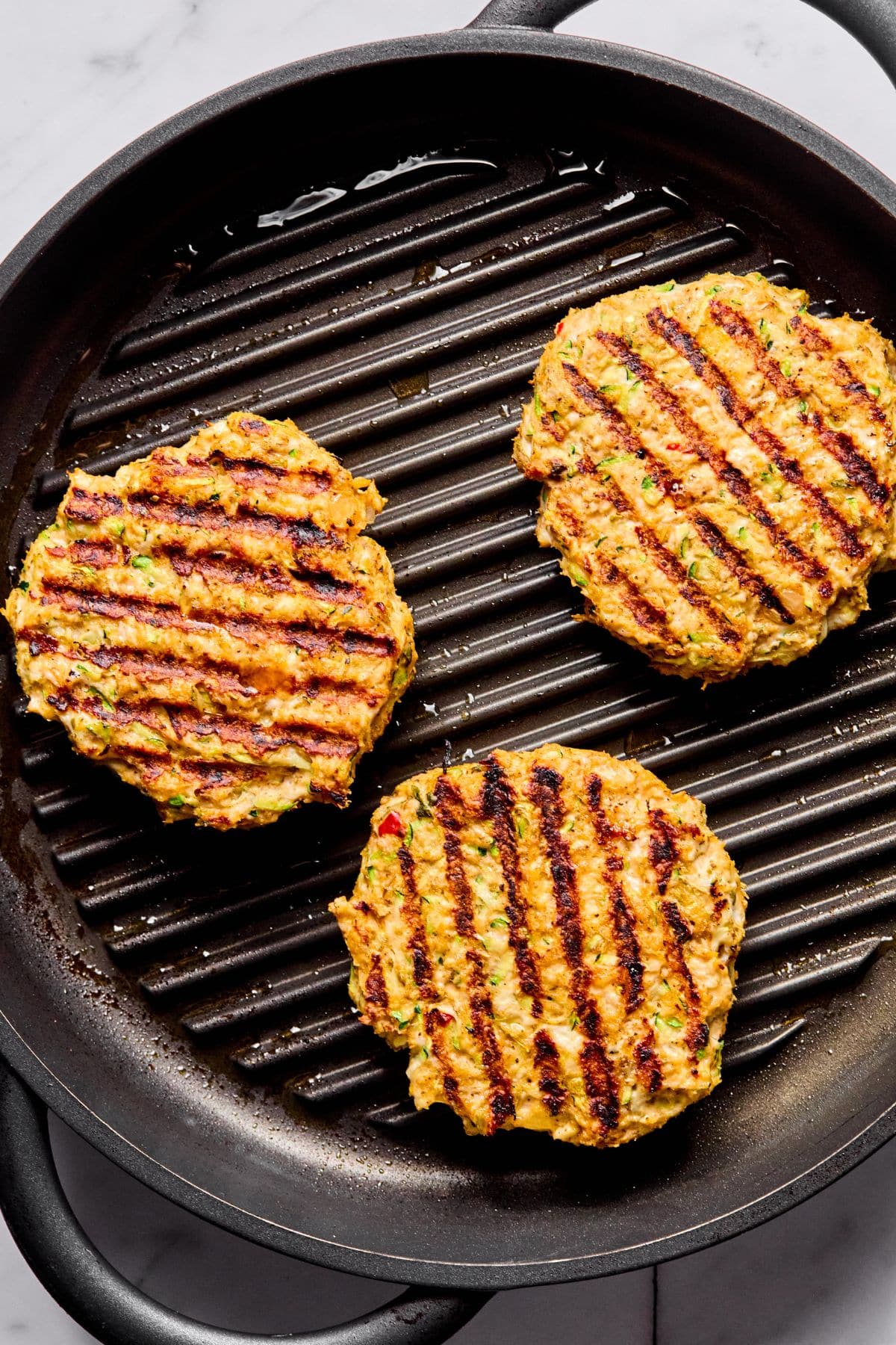 The burgers flipped on the skillet.
